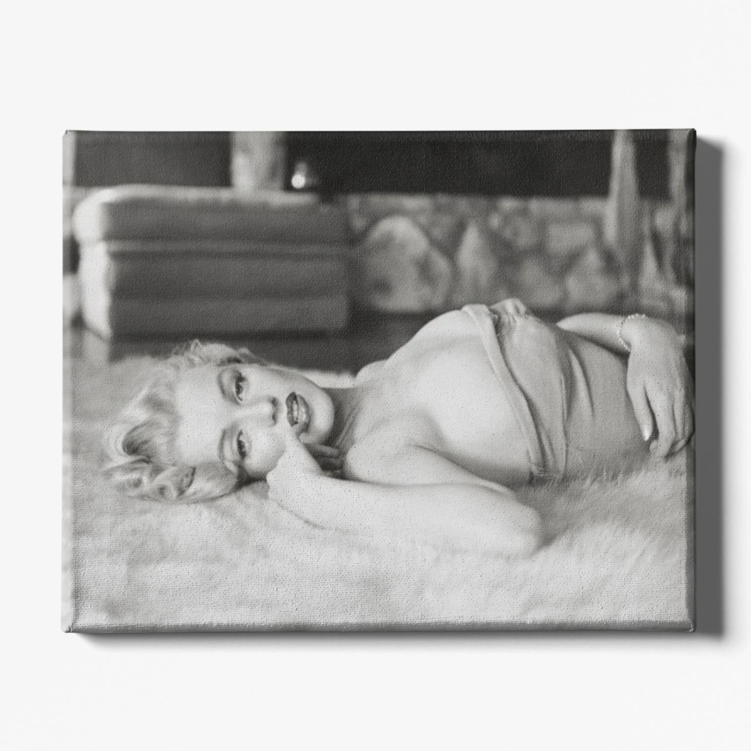 Black and white photograph of a person lying on a couch with a blurred background