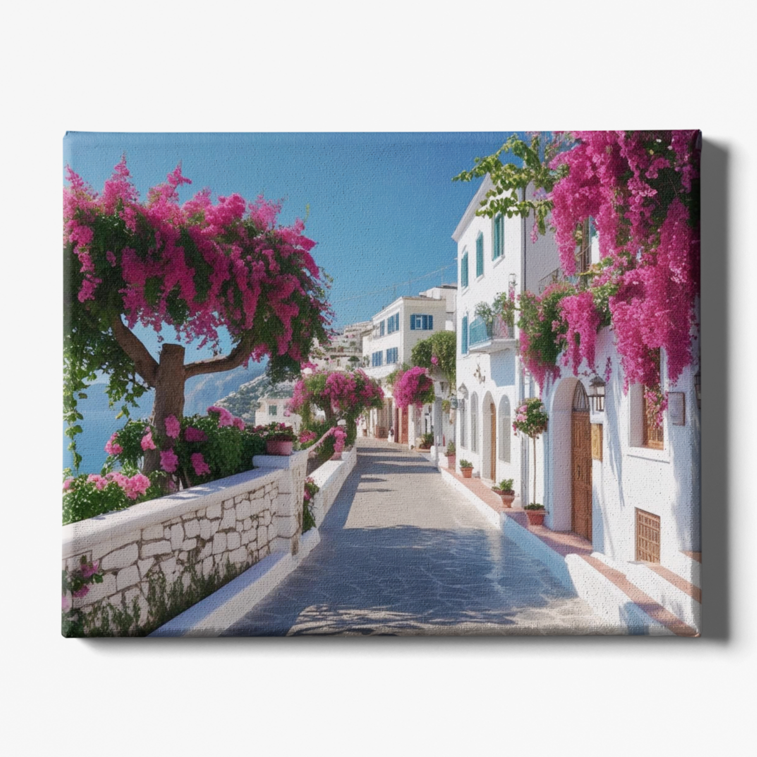 Tropical street scene with white buildings, pink flowers, and a clear blue sky.